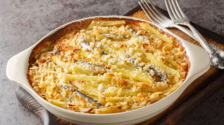 Pečené brambory s anchovy v bílé mýdlovité formě.