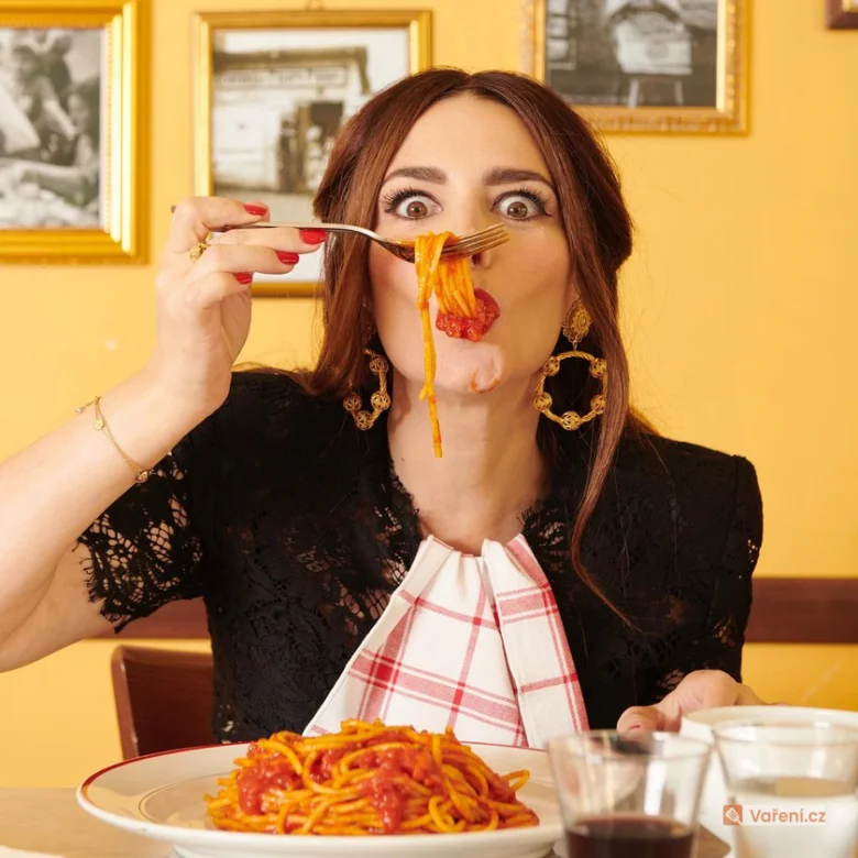 Žena jí talíř boloňských špaget v restauraci.