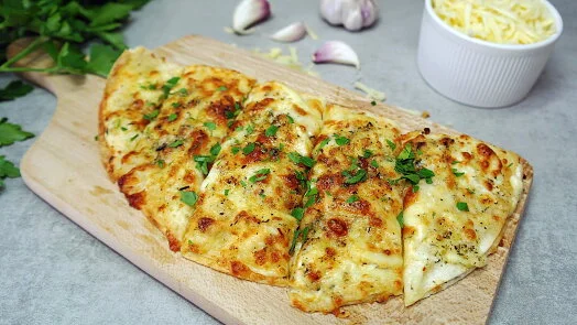 Pečená pizza z tortilly sýrovou náplní na dřevěném podnosu.