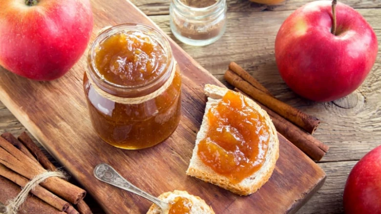 Domácí jablková marmeláda na chlebu s čerstvými jablem.
