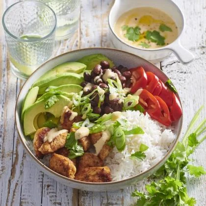 Mísa s kuřecím masem, fazolemi, rýží a mexickými ingrediencemi.
