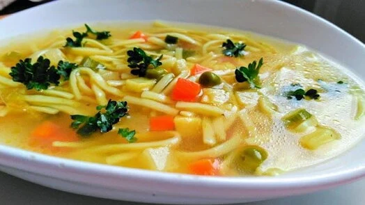 Miska se slepičím vývarem s nudlemi a zeleninou.