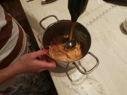 Připrava hummusu pomocí ponorného mixéru v kuchyňské misce.