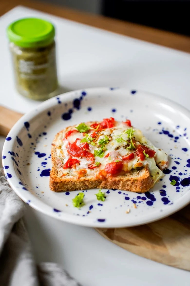 Zapečený toast s rajčatovou omáčkou, sýrem a bylinkami.
