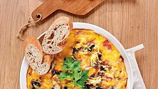 Pečená omletka s chlebem a petrželkou na dřevěném podkladu