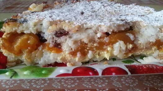 Kousek rýžového nákypu s ovocným náplní posypaným cukrem.