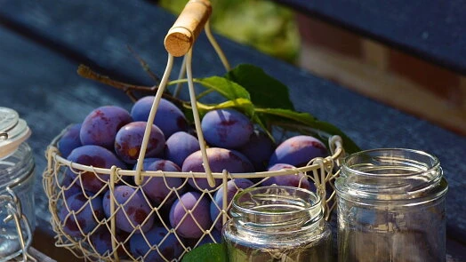Plums in basket with jars