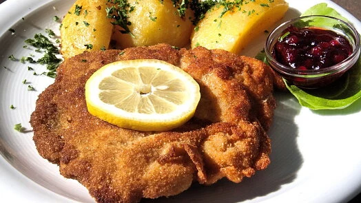 Zlatě opečený kuřecí řízek s citronem a bramborami.