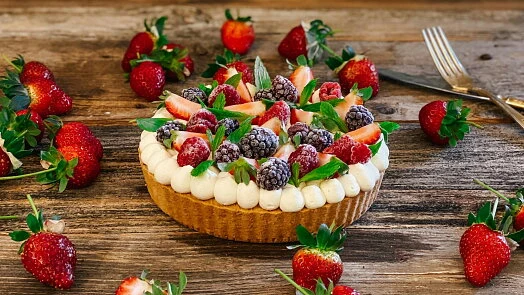 Dort s ovocem a krémem z mascarpone a šlehačky na dřevěném stole.