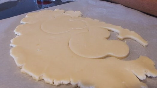 Rozválené těsto na sušenky s vykrojenými tvary.