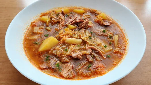 Miska s kapustovou polévkou od babičky se zelím, masem a bramborami.
