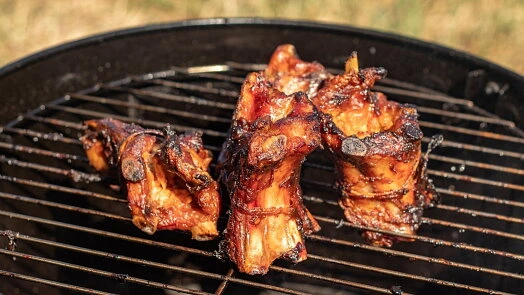 Pečená žebra na mřížce grilu s medovou omáčkou.