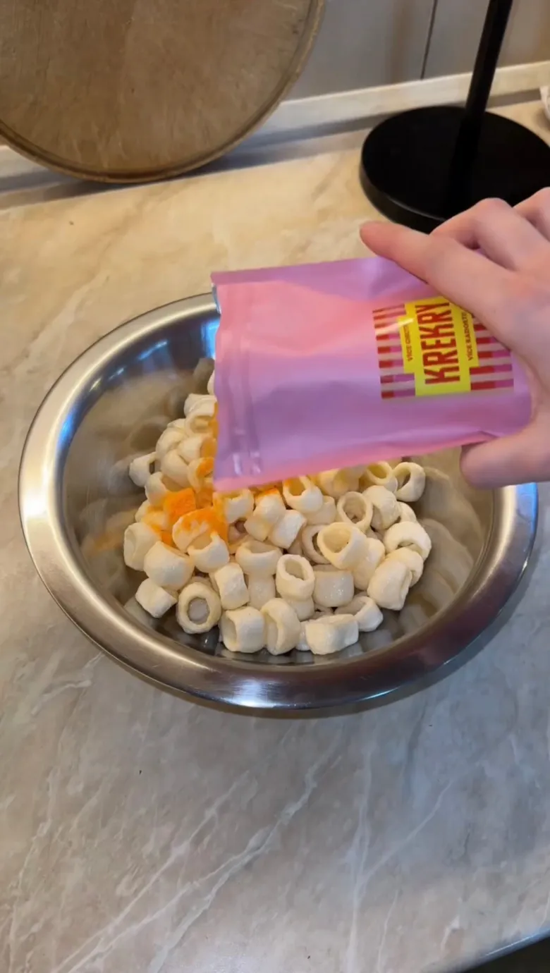 Ruce nalévají mražené krokety do mísy s těstem.