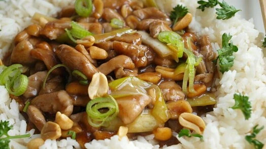 Kung Pao kuřecí maso s oříšky a zelenou na rýži.