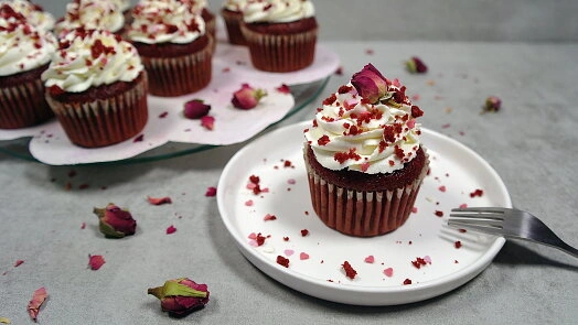 Red Velvet dortíčka s bílým krémem a sušenými růžovými květy.