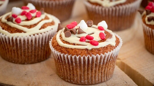 Hrníčkové muffiny z mrkve s bílým krémem a ozdobami.