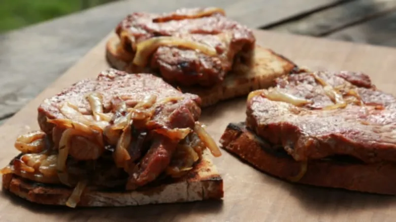 Připravené vepřové krkovice s cibulí na toastu.