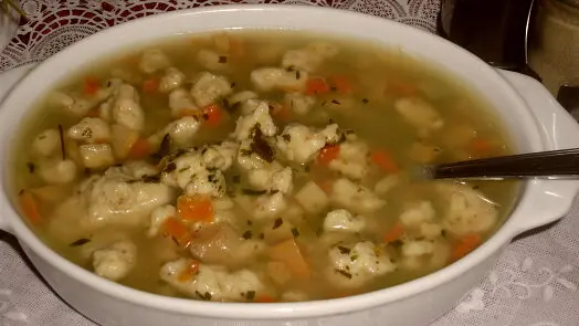 Yeast dumpling soup with carrots and herbs