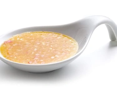 Domácí majonéza v bílé misce na světlém pozadí.