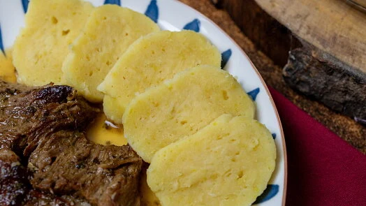 Příprava bramborových knedlíků: hotové žluté plátky s masem.