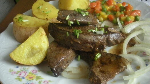 Připravená játra s bramborami a zeleninou na talíři.