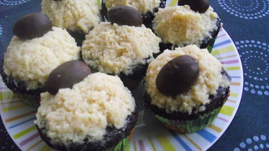 Čokoládové muffiny s kokosovou vrstvou a čokolády na talíři.