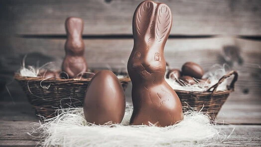 Čokoládový velikonoční beránek s vejcem v košíku.