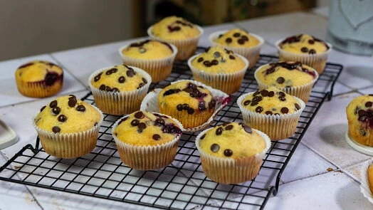 Čerstvé hrníčkové muffiny s čokoládovými kousky na mřížce.