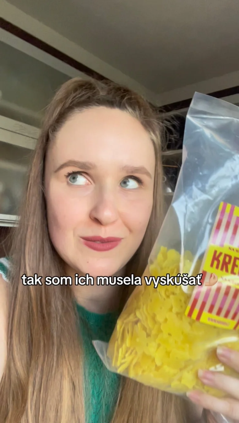 Žena drží sáček se zmraženými krokety pro pečení v troubě.